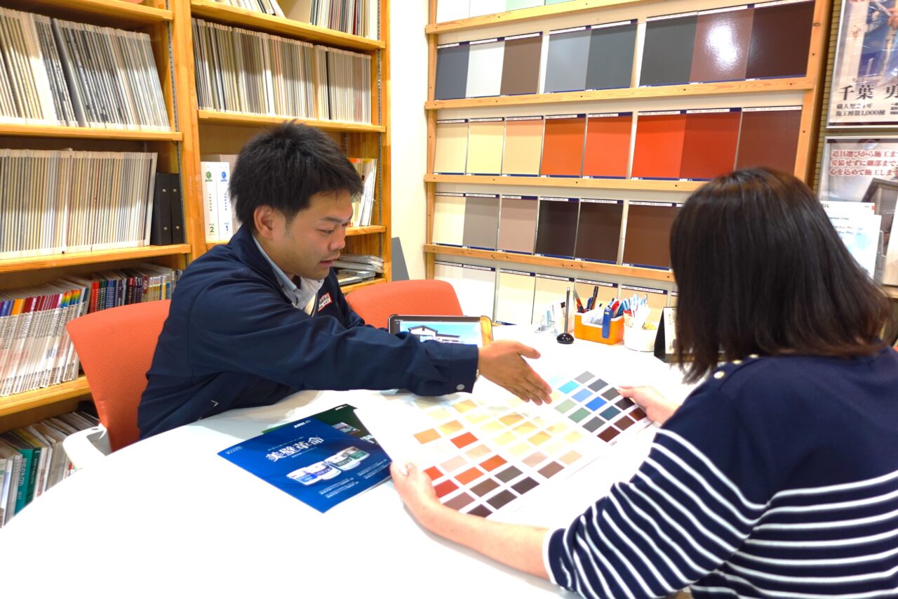 戸建住宅の外壁について現地で相談する様子